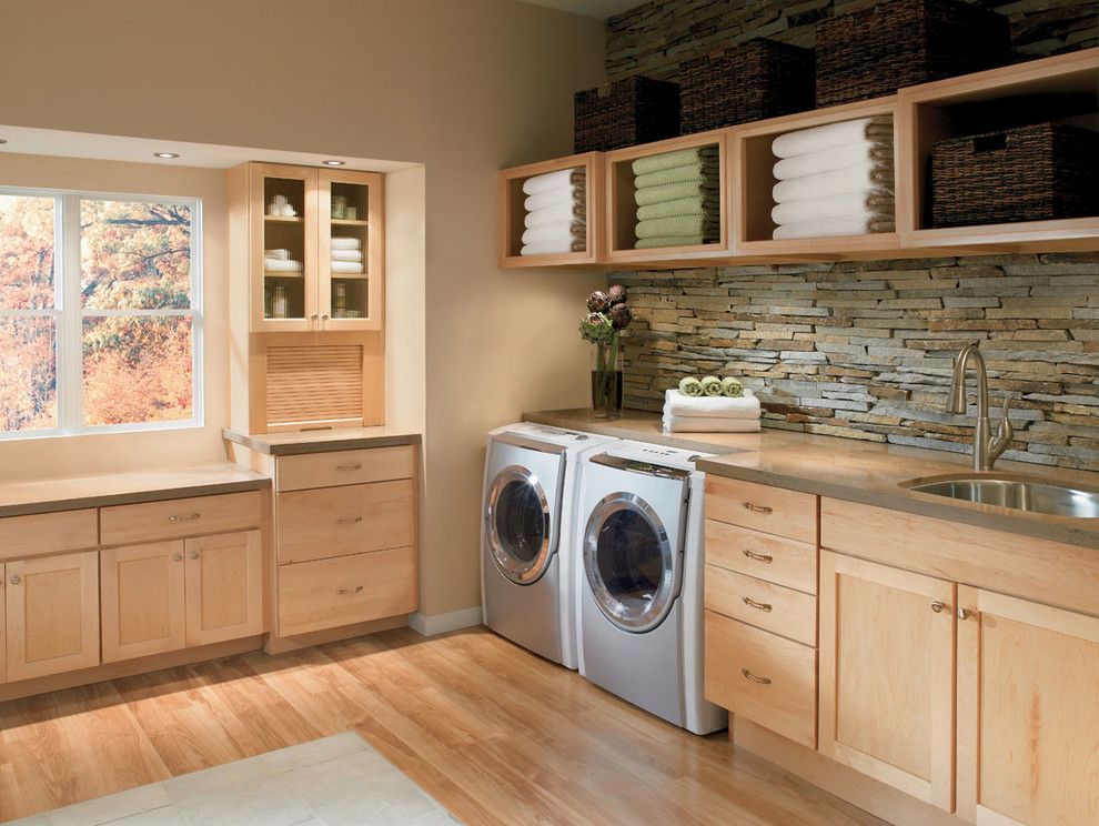 Inspiration for a large tropical l-shaped dedicated laundry room in San Diego with an undermount sink, shaker cabinets, light wood cabinets, solid surface benchtops, beige walls, medium hardwood floors and a side-by-side washer and dryer.