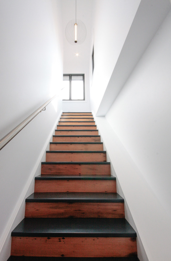 Diseño de escalera recta moderna con escalones de madera pintada, contrahuellas de madera y barandilla de metal