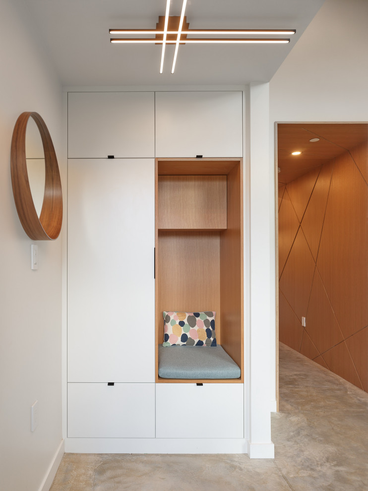 This is an example of a small contemporary foyer in Vancouver with white walls, concrete flooring, a single front door, a black front door and grey floors.