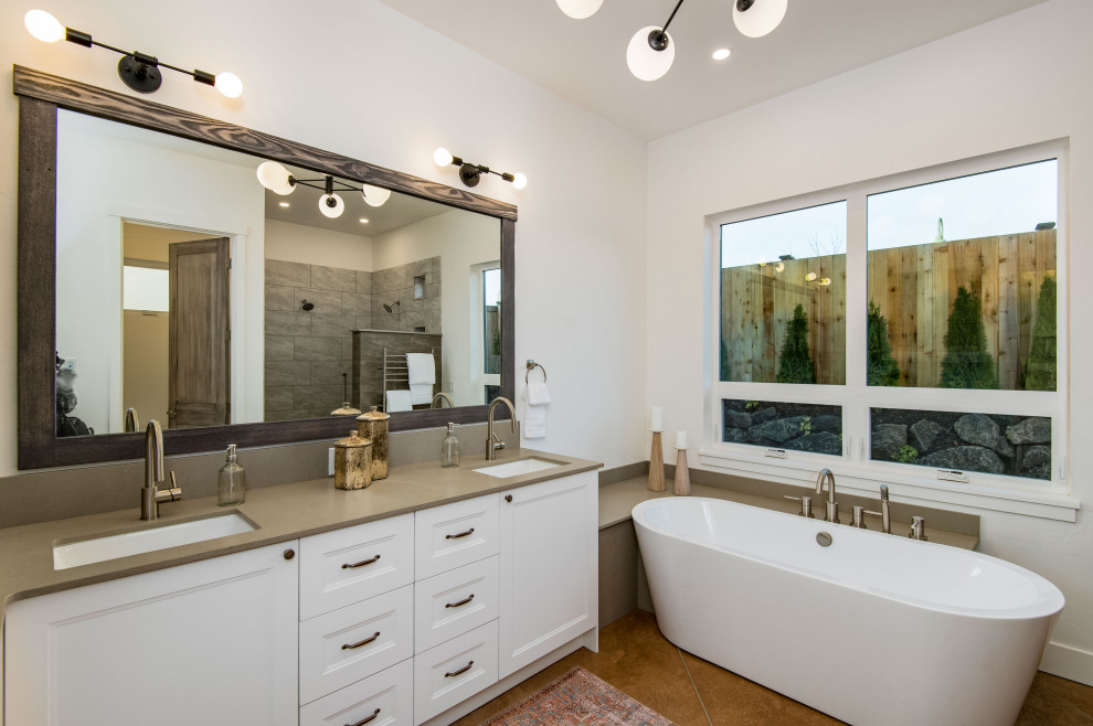 Large french country master gray tile and stone slab concrete floor, brown floor and double-sink bathroom photo in Portland with shaker cabinets, white cabinets, a two-piece toilet, white walls, an undermount sink, solid surface countertops, gray countertops and a built-in vanity
