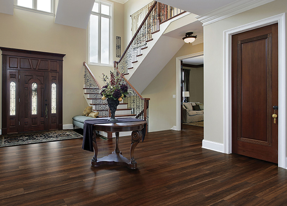 Example of a large classic dark wood floor and brown floor foyer design with beige walls and a dark wood front door