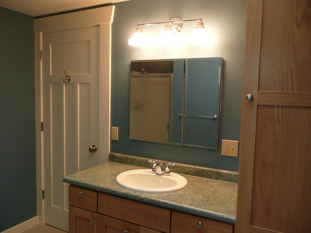 Inspiration for a mid-sized arts and crafts 3/4 bathroom in Seattle with a drop-in sink, shaker cabinets, laminate benchtops, blue walls and linoleum floors.