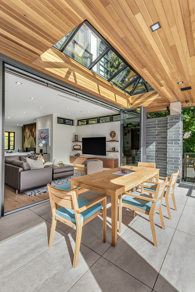 Photo of a mid-sized contemporary backyard patio in Vancouver with a roof extension and concrete pavers.