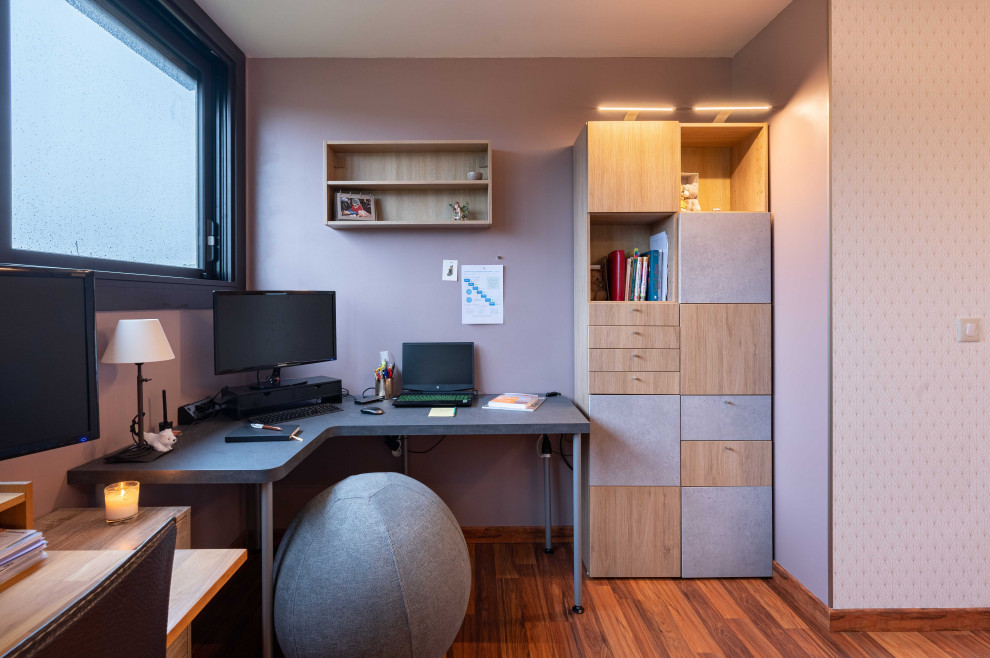 Пример оригинального дизайна: рабочее место среднего размера в современном стиле с фиолетовыми стенами, паркетным полом среднего тона, отдельно стоящим рабочим столом, коричневым полом и обоями на стенах без камина