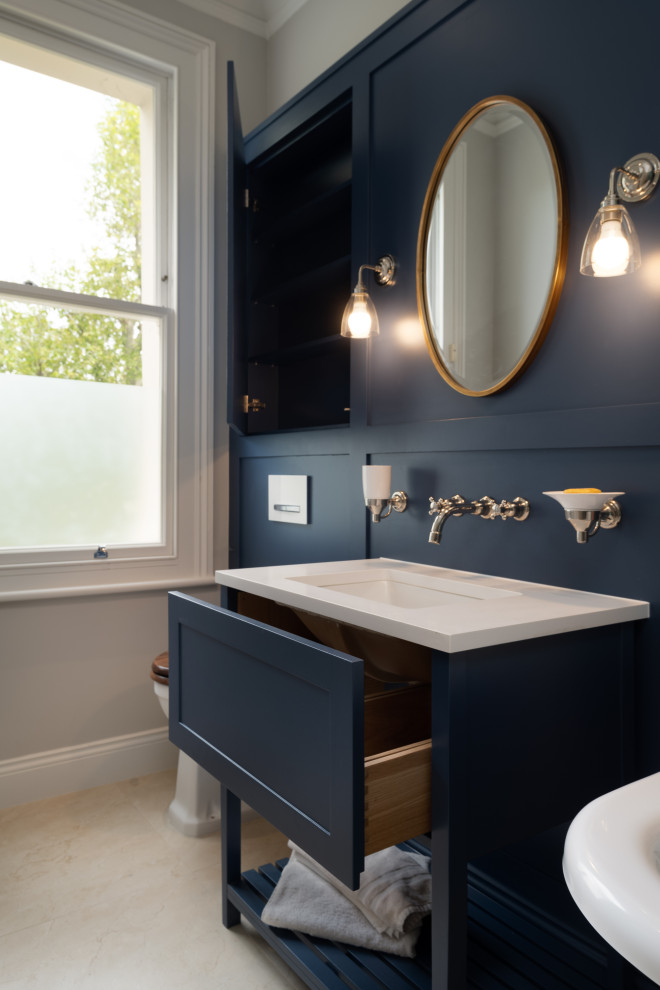 Источник вдохновения для домашнего уюта: большая главная ванная комната в классическом стиле с фасадами в стиле шейкер, синими фасадами, открытым душем, инсталляцией, синими стенами, врезной раковиной, открытым душем, белой столешницей, акцентной стеной, тумбой под одну раковину, встроенной тумбой, панелями на части стены, отдельно стоящей ванной, синей плиткой, терракотовой плиткой, мраморным полом, столешницей из искусственного кварца и белым полом