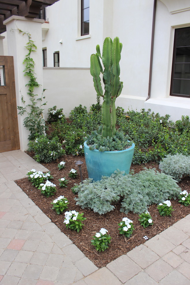 This is an example of a mid-sized courtyard partial sun xeriscape in Los Angeles with a garden path and concrete pavers.