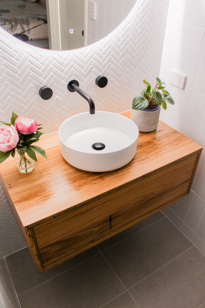 Inspiration for a small modern 3/4 bathroom in Perth with furniture-like cabinets, dark wood cabinets, an open shower, a one-piece toilet, white tile, ceramic tile, white walls, porcelain floors, a vessel sink, wood benchtops, grey floor, an open shower and brown benchtops.