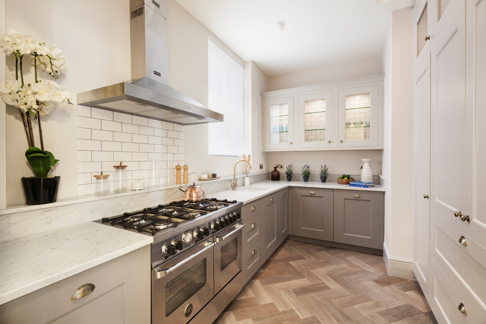 Inspiration for a small transitional l-shaped separate kitchen in London with granite benchtops, white splashback, subway tile splashback, stainless steel appliances, no island, white benchtop, a single-bowl sink, glass-front cabinets, white cabinets, beige floor and medium hardwood floors.