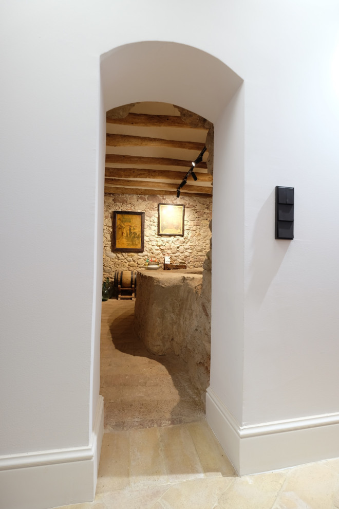 Idée de décoration pour une petite cave à vin chalet avec tomettes au sol, un présentoir et un sol blanc.