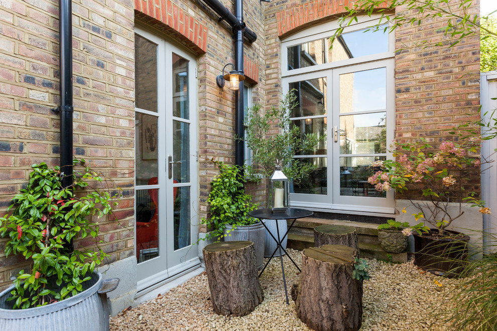 This is an example of a small scandinavian patio in London with gravel and no cover.