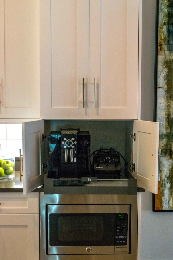 Example of a mid-sized transitional single-wall light wood floor and beige floor open concept kitchen design in Miami with shaker cabinets, an island, an undermount sink, white cabinets, marble countertops, white backsplash, subway tile backsplash and stainless steel appliances