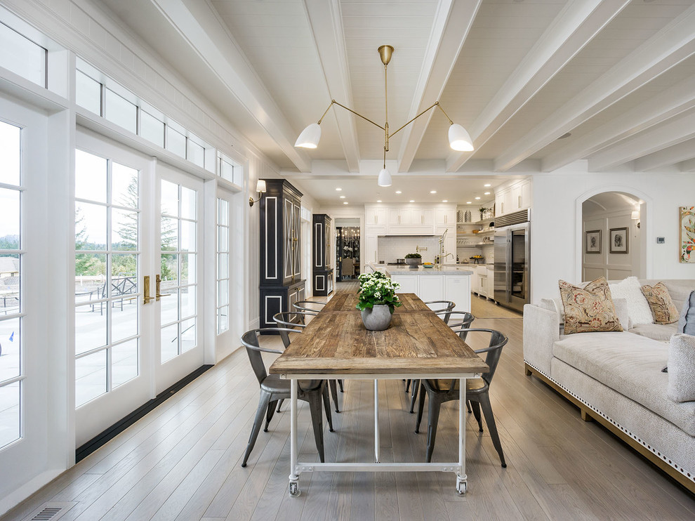 Photo of a country open plan dining in Portland with white walls, light hardwood floors and beige floor.