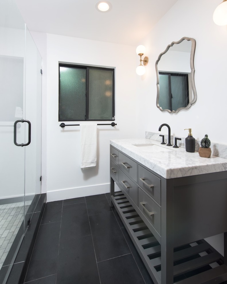 Design ideas for a mid-sized modern 3/4 bathroom in Los Angeles with furniture-like cabinets, grey cabinets, an alcove shower, white walls, slate floors, an undermount sink, marble benchtops, black floor and a hinged shower door.