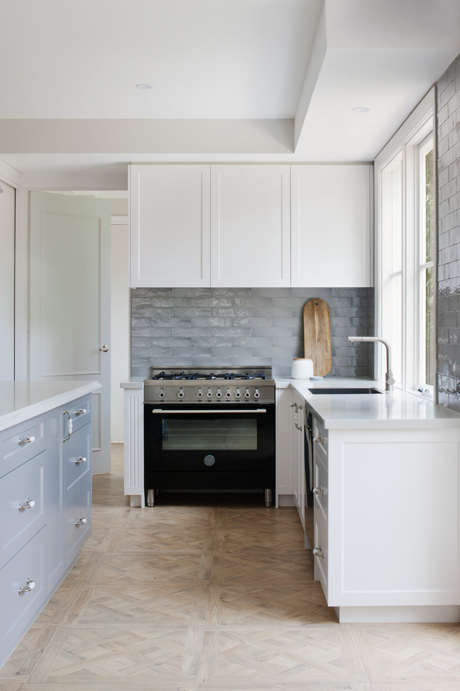 Design ideas for a large country l-shaped kitchen pantry in Melbourne with a drop-in sink, beaded inset cabinets, white cabinets, solid surface benchtops, subway tile splashback, stainless steel appliances and with island.