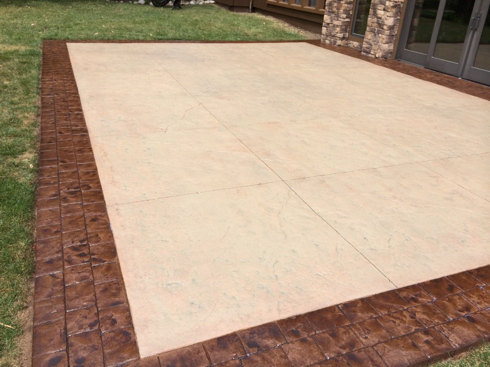 This is an example of a mid-sized mediterranean backyard patio in Kansas City with stamped concrete and no cover.