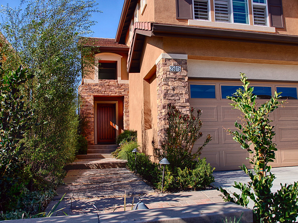 Large mountain style front door photo in Orange County with brown walls and a light wood front door