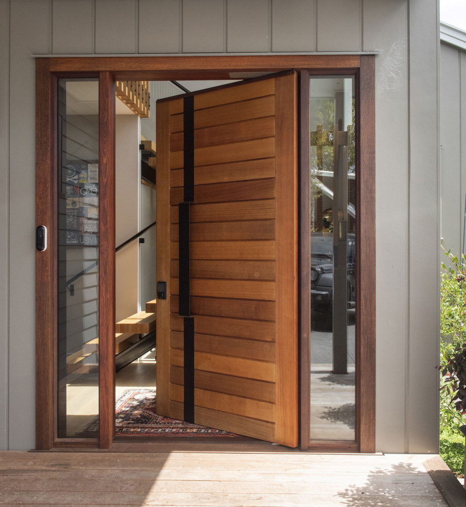 Idées déco pour un hall d'entrée contemporain en bois avec parquet clair, une porte pivot et une porte en bois clair.