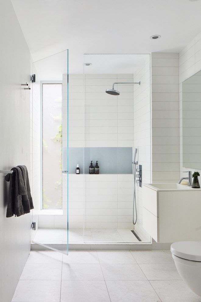 Photo of a contemporary 3/4 bathroom in New York with flat-panel cabinets, an alcove shower and a hinged shower door.