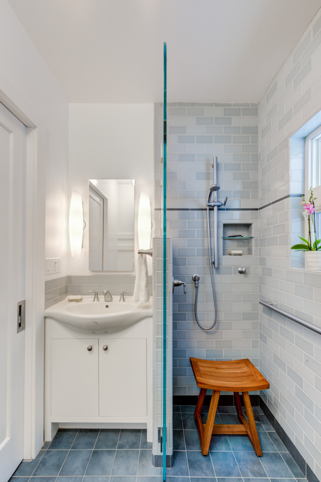 Design ideas for a small traditional bathroom in San Francisco with flat-panel cabinets, white cabinets, a built-in shower, a wall mounted toilet, blue tiles, ceramic tiles, white walls, porcelain flooring, an integrated sink, solid surface worktops, blue floors, an open shower, white worktops, a wall niche, a single sink and a built in vanity unit.