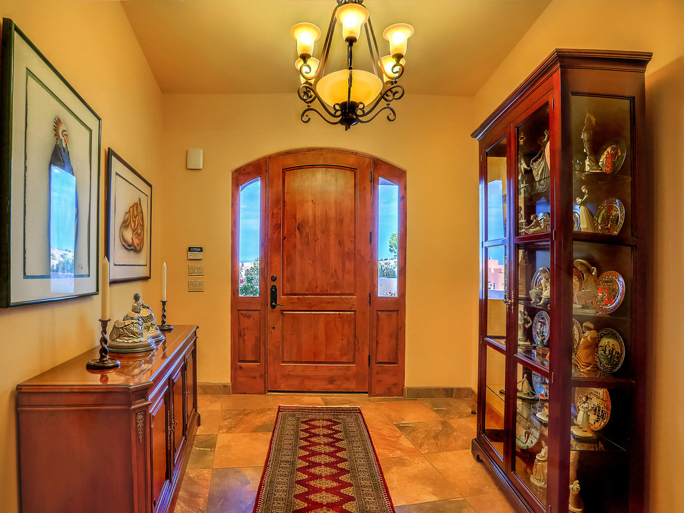 Inspiration for a mid-sized foyer in Albuquerque with beige walls, travertine floors, a single front door, a medium wood front door and beige floor.