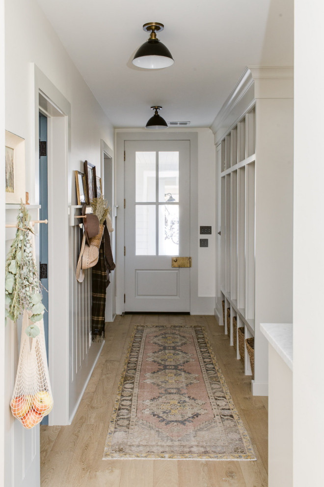 Large country mudroom in Dallas with white walls, light hardwood floors, a gray front door and brown floor.