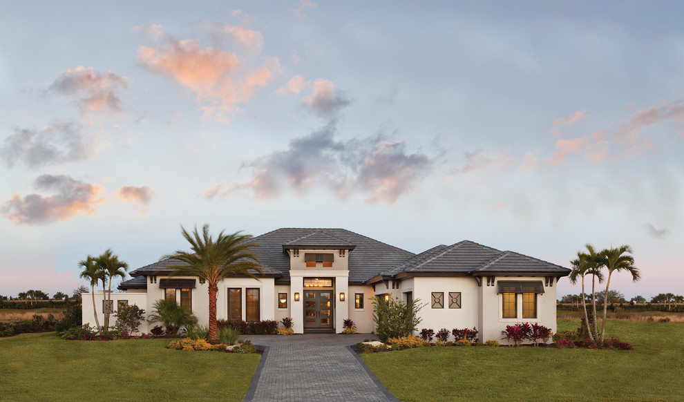 Inspiration for a large transitional one-storey stucco beige house exterior in Tampa with a hip roof and a tile roof.