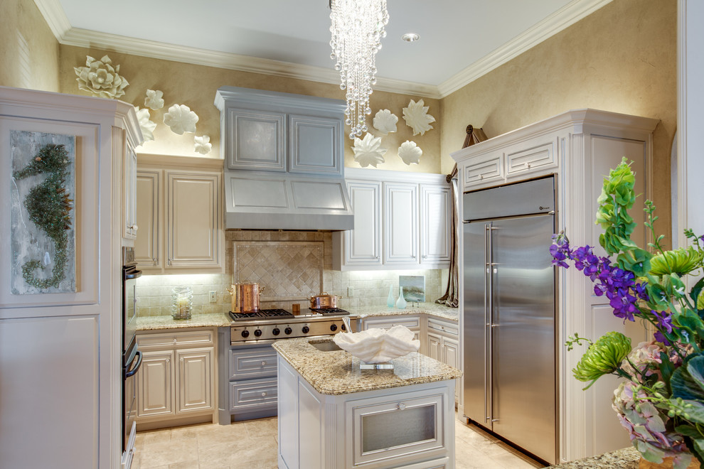 This is an example of a traditional kitchen in Atlanta with raised-panel cabinets, beige cabinets, granite benchtops, beige splashback, stone tile splashback and stainless steel appliances.