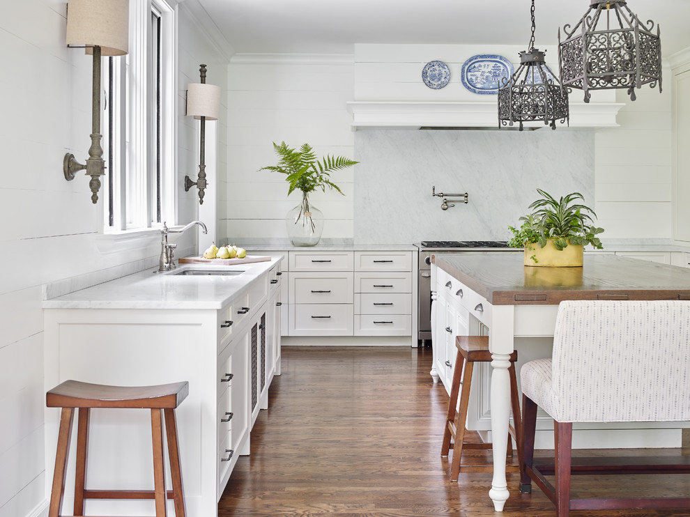 Inspiration for a traditional l-shaped kitchen in Atlanta with an undermount sink, shaker cabinets, white cabinets, white splashback, stone slab splashback, stainless steel appliances, dark hardwood floors and with island.