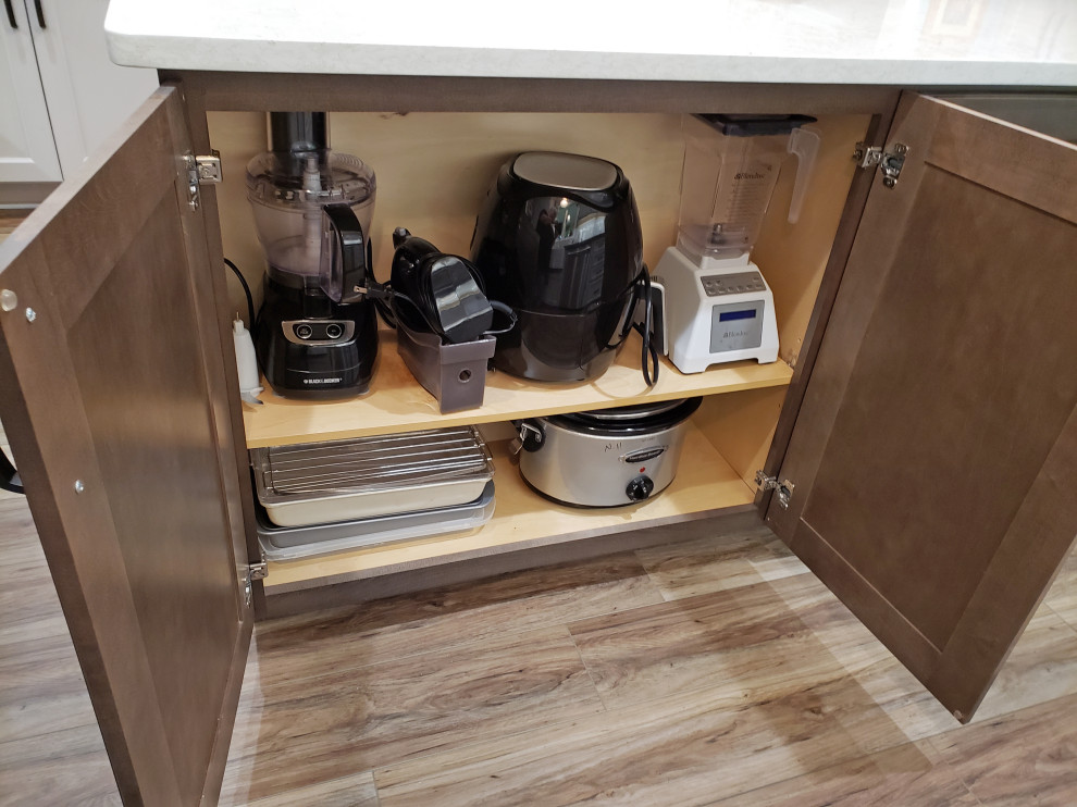 Example of a mid-sized transitional l-shaped vinyl floor and brown floor eat-in kitchen design in Nashville with a farmhouse sink, recessed-panel cabinets, gray cabinets, quartz countertops, gray backsplash, ceramic backsplash, stainless steel appliances, an island and brown countertops