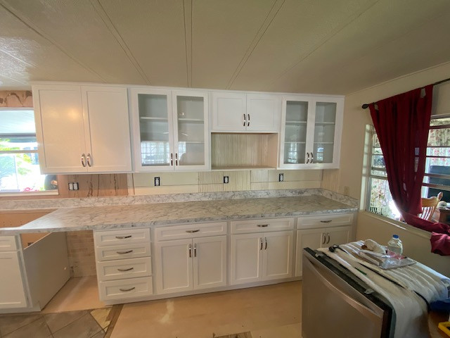 Large galley eat-in kitchen photo with shaker cabinets, white cabinets, laminate countertops, a peninsula and white countertops