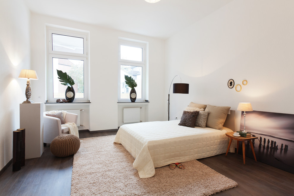 Photo of a large contemporary master bedroom in Dortmund with white walls, dark hardwood floors and no fireplace.