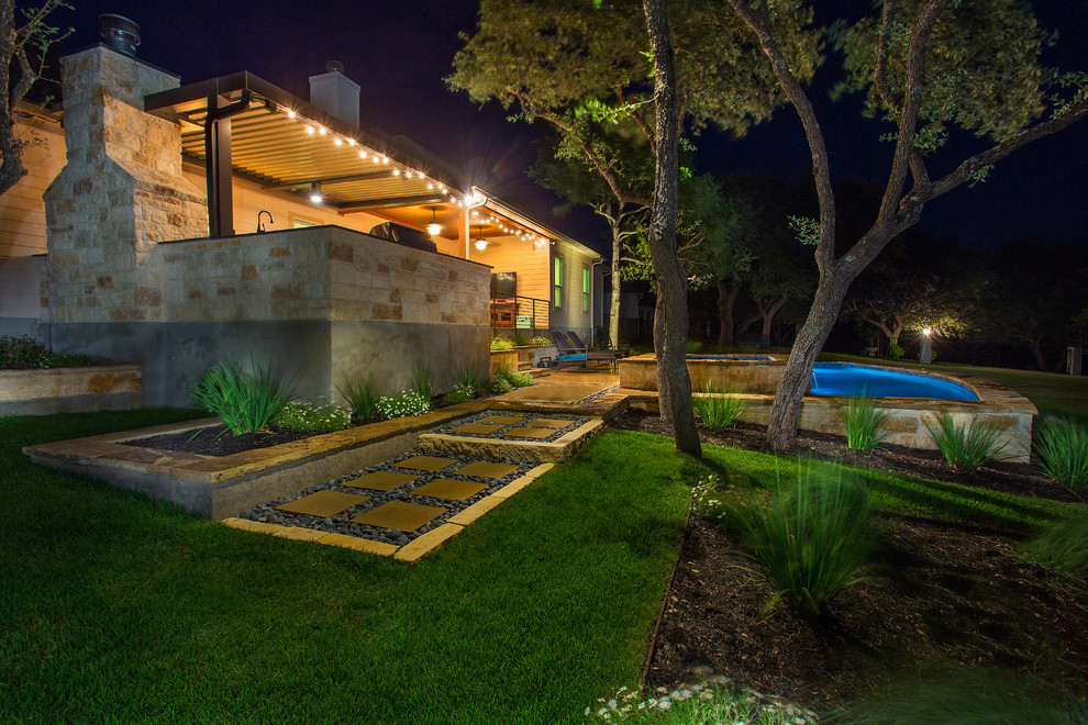 Photo of a mid-sized traditional backyard custom-shaped lap pool in Austin with a water feature and concrete slab.