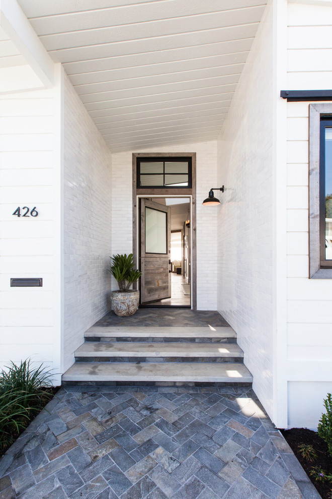 Design ideas for a mid-sized beach style front door in Orange County with white walls, a single front door, a medium wood front door, slate floors and blue floor.