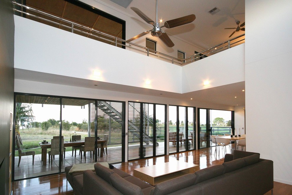 Mid-sized contemporary open concept living room in Sunshine Coast with grey walls and bamboo floors.