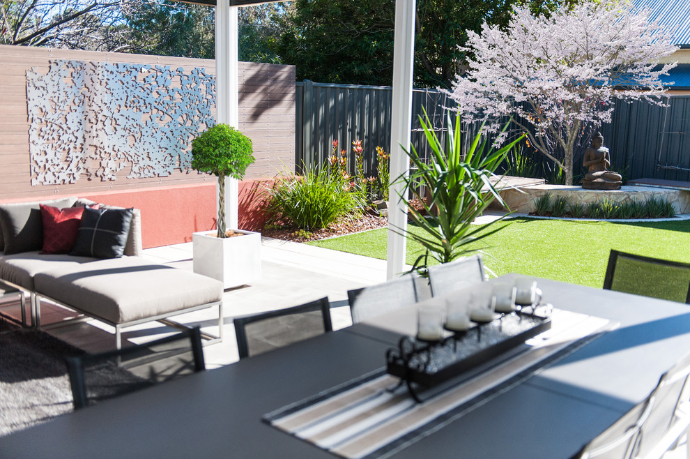 This is an example of a mid-sized modern backyard patio in Adelaide with a roof extension.