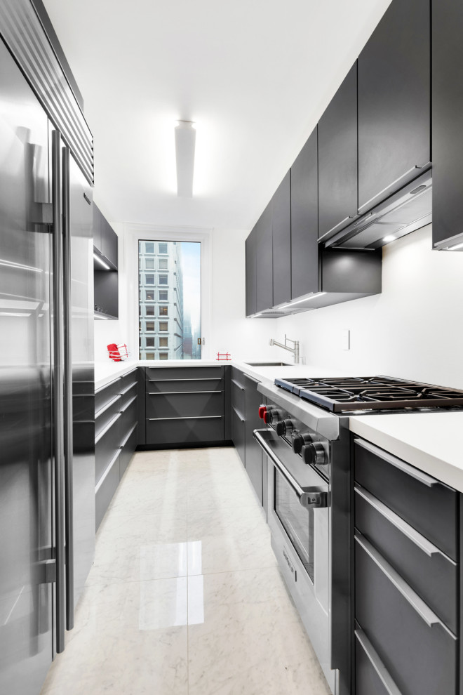 Contemporary u-shaped kitchen in New York with an undermount sink, flat-panel cabinets, black cabinets, no island, white floor and white benchtop.