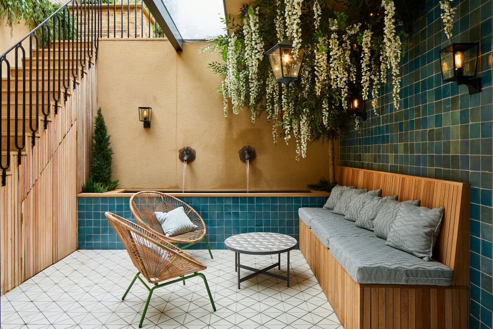 Photo of a mediterranean courtyard patio in London with a water feature and tile.