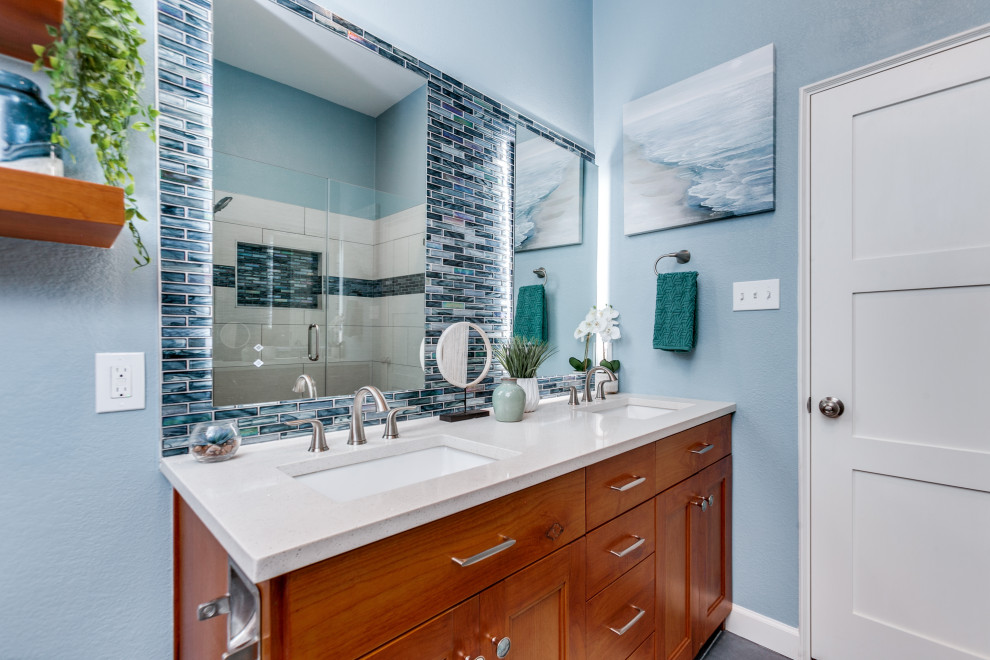 На фото: детская ванная комната среднего размера в морском стиле с фасадами в стиле шейкер, фасадами цвета дерева среднего тона, душем в нише, раздельным унитазом, разноцветной плиткой, керамогранитной плиткой, синими стенами, полом из керамогранита, врезной раковиной, столешницей из искусственного кварца, серым полом, душем с распашными дверями, белой столешницей, нишей, тумбой под две раковины и напольной тумбой с