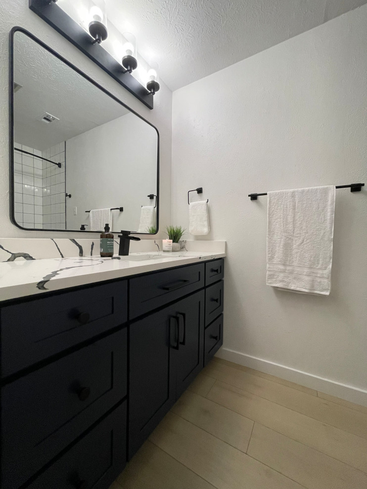 Example of a small minimalist kids' vinyl floor, brown floor and single-sink bathroom design in Dallas with shaker cabinets, blue cabinets, white walls, an undermount sink, quartz countertops, multicolored countertops and a built-in vanity