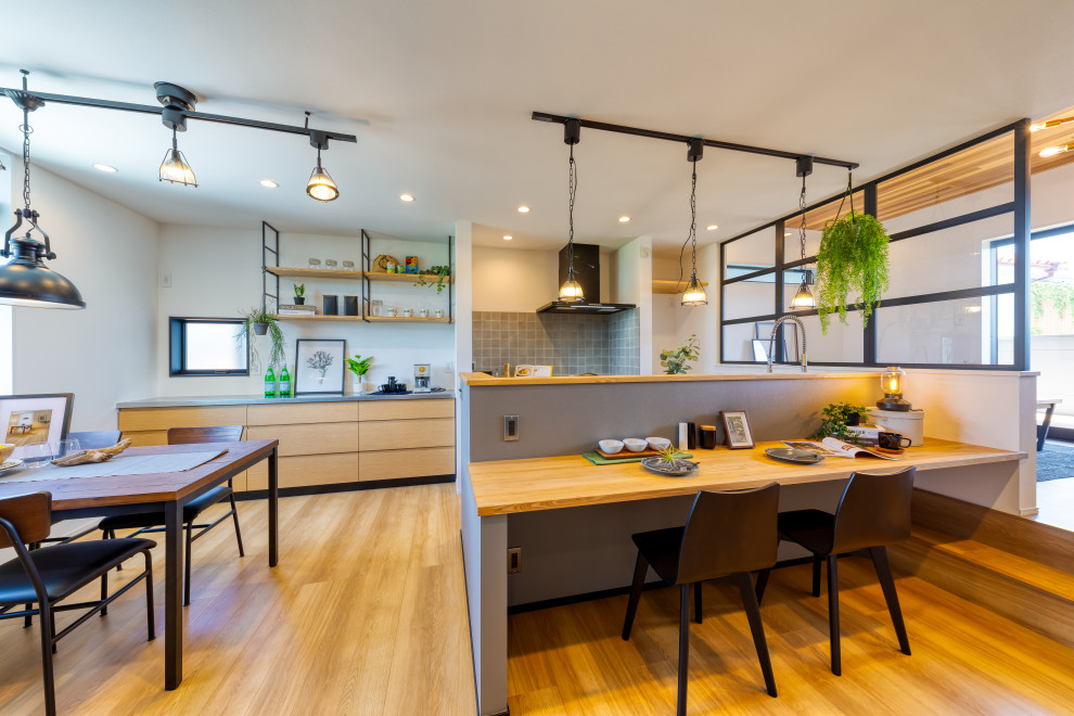 This is an example of a large industrial grey and brown galley kitchen/diner in Osaka with stainless steel worktops, an island and brown worktops.