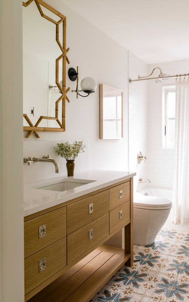 Пример оригинального дизайна: ванная комната в морском стиле с плоскими фасадами, фасадами цвета дерева среднего тона, ванной в нише, душем над ванной, белой плиткой, белыми стенами, врезной раковиной, белым полом, шторкой для ванной, белой столешницей и напольной тумбой