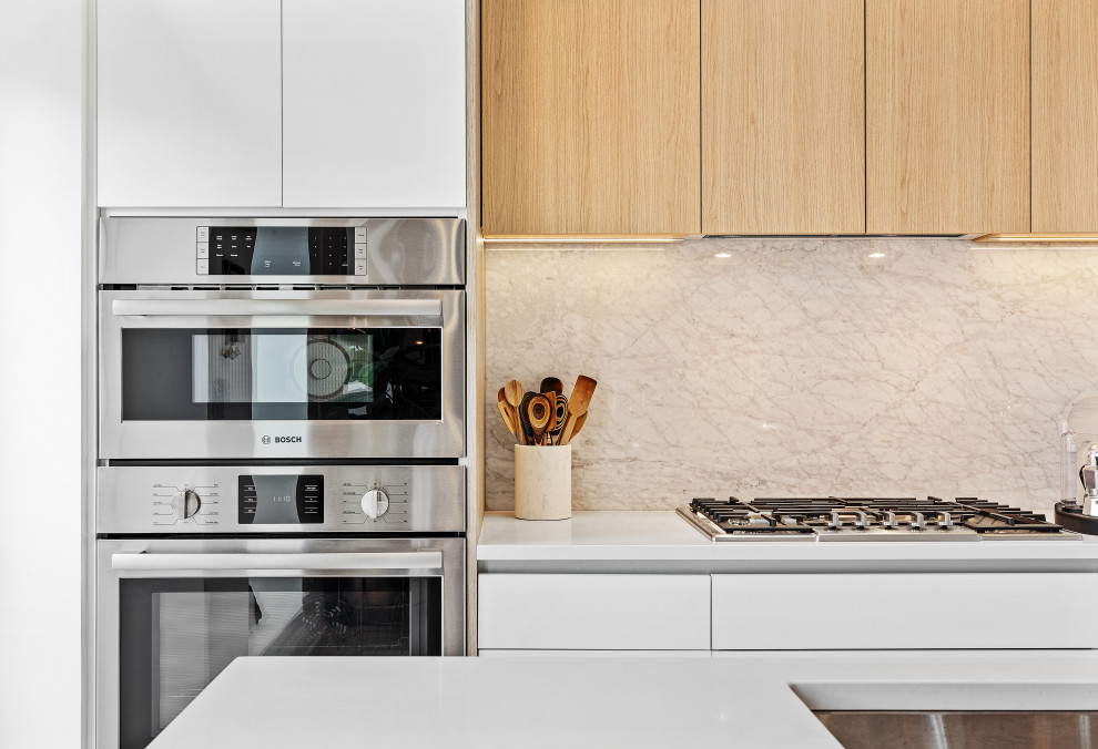 Inredning av ett modernt litet vit linjärt vitt kök med öppen planlösning, med en undermonterad diskho, släta luckor, bänkskiva i kvarts, integrerade vitvaror, ljust trägolv och en köksö