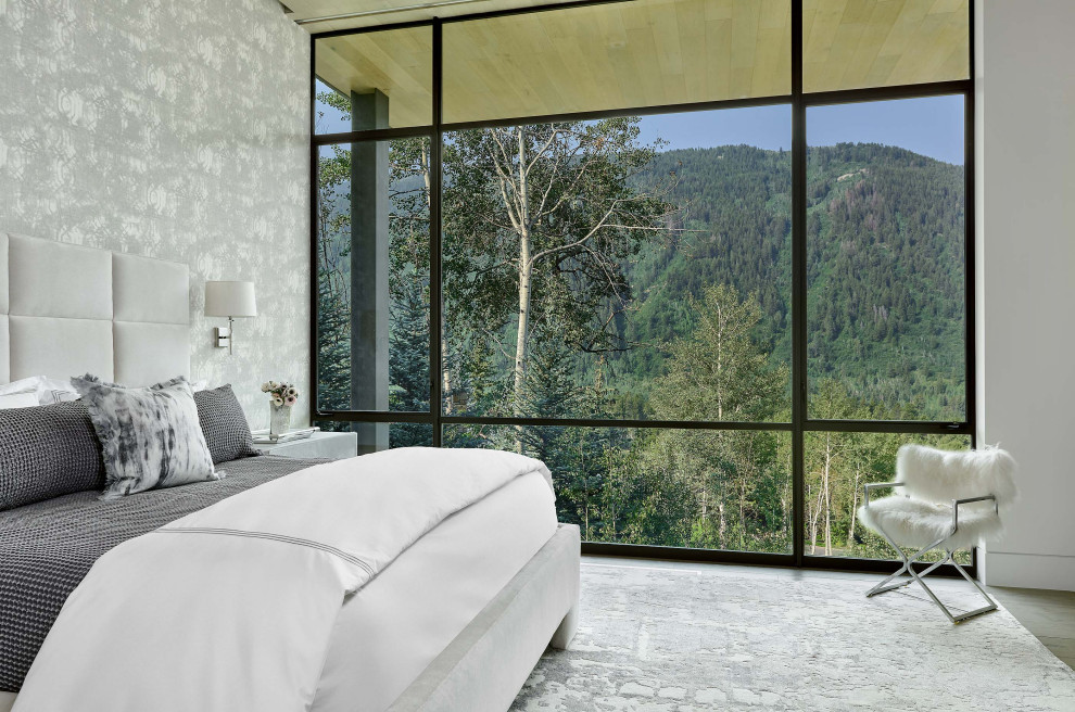 Esempio di una camera da letto design con pareti grigie, pavimento in legno massello medio, pavimento marrone e carta da parati