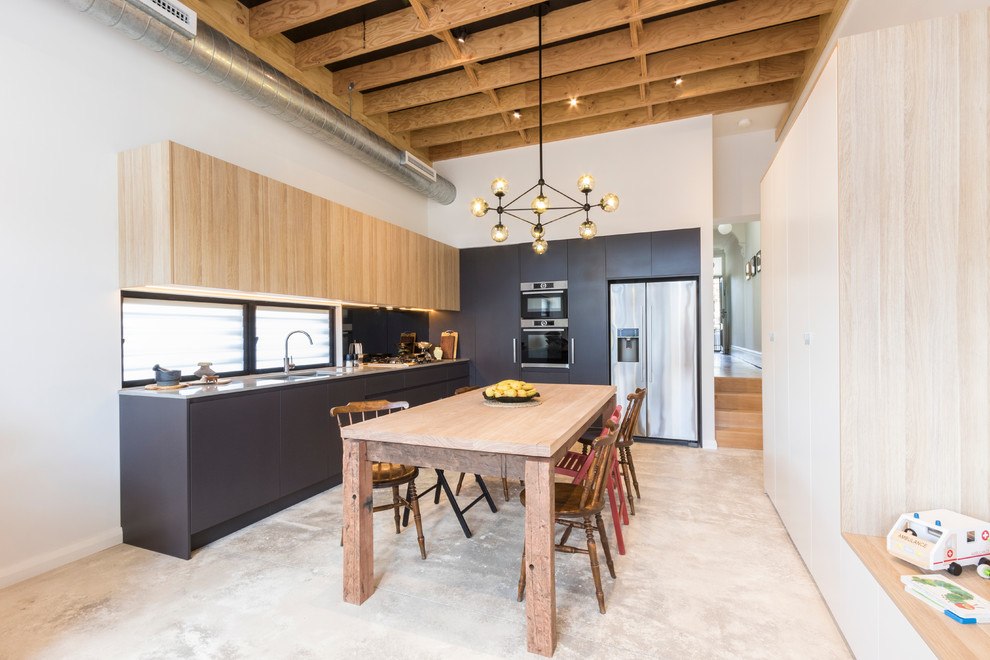 Photo of a mid-sized transitional l-shaped eat-in kitchen in Other with a double-bowl sink, light wood cabinets, quartz benchtops, stainless steel appliances, concrete floors and no island.