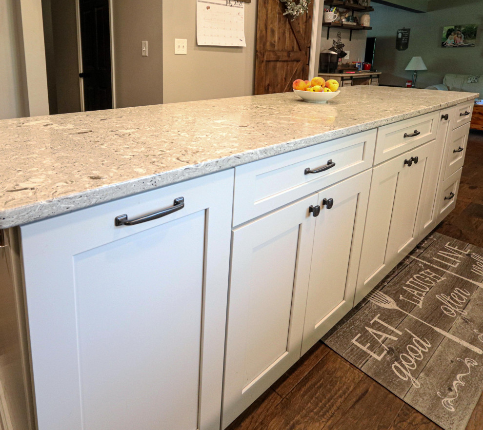 This is an example of a mid-sized transitional galley eat-in kitchen in Cleveland with an undermount sink, shaker cabinets, white cabinets, quartz benchtops, multi-coloured splashback, mosaic tile splashback, stainless steel appliances, medium hardwood floors, with island, brown floor and beige benchtop.