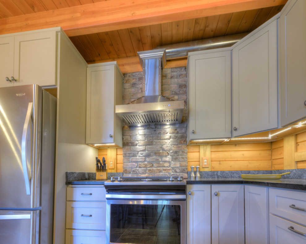 Eat-in kitchen - mid-sized rustic u-shaped porcelain tile, gray floor and exposed beam eat-in kitchen idea in Richmond with a double-bowl sink, shaker cabinets, gray cabinets, soapstone countertops, brick backsplash, stainless steel appliances, an island and black countertops