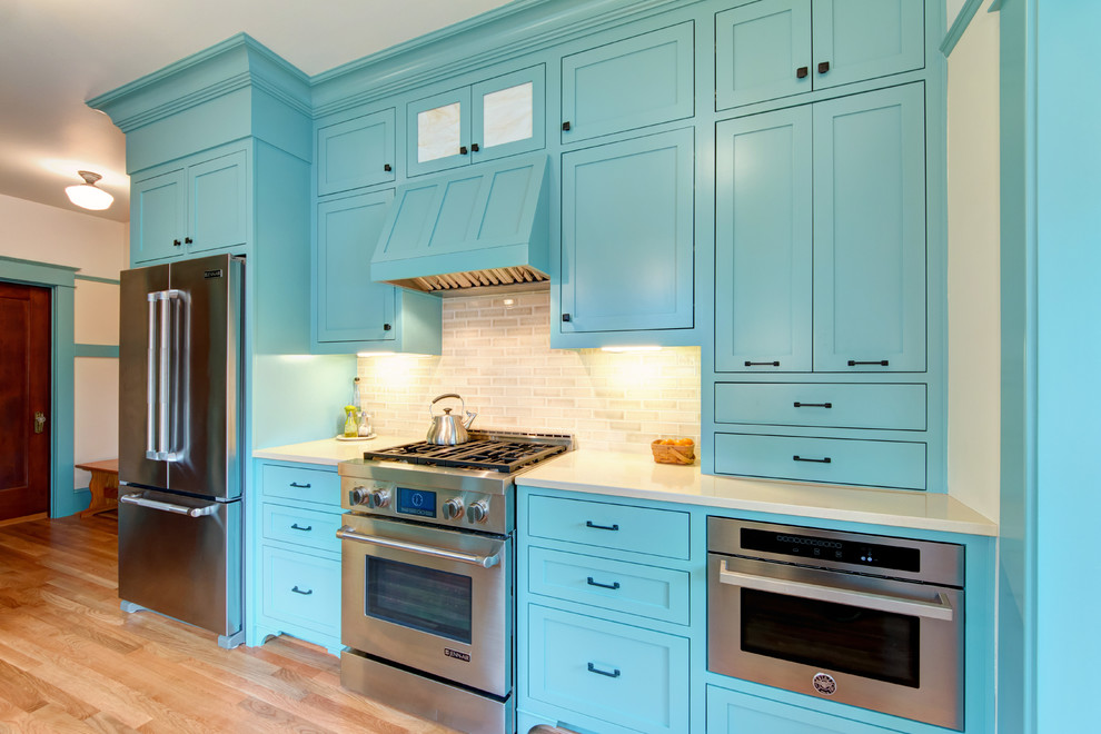 Design ideas for a large traditional separate kitchen in Portland with a farmhouse sink, shaker cabinets, quartz benchtops, beige splashback, subway tile splashback, stainless steel appliances, light hardwood floors, no island and turquoise cabinets.