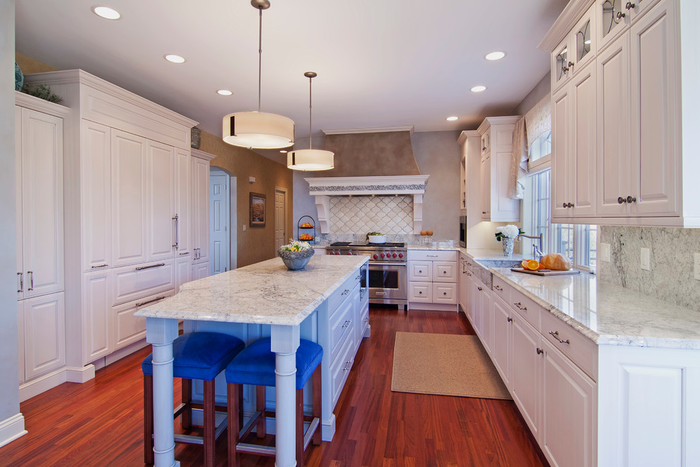 This is an example of a traditional u-shaped kitchen in Minneapolis with an integrated sink, raised-panel cabinets, white cabinets, white splashback and panelled appliances.
