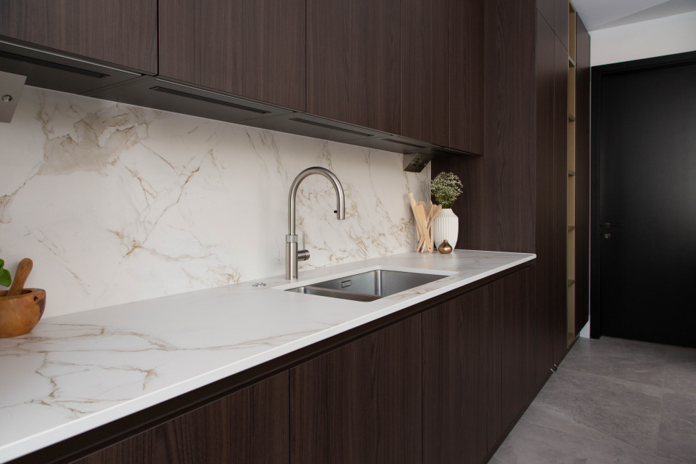 Example of a large trendy l-shaped porcelain tile, beige floor and coffered ceiling open concept kitchen design in London with a double-bowl sink, flat-panel cabinets, dark wood cabinets, white backsplash, porcelain backsplash, paneled appliances, a peninsula and white countertops