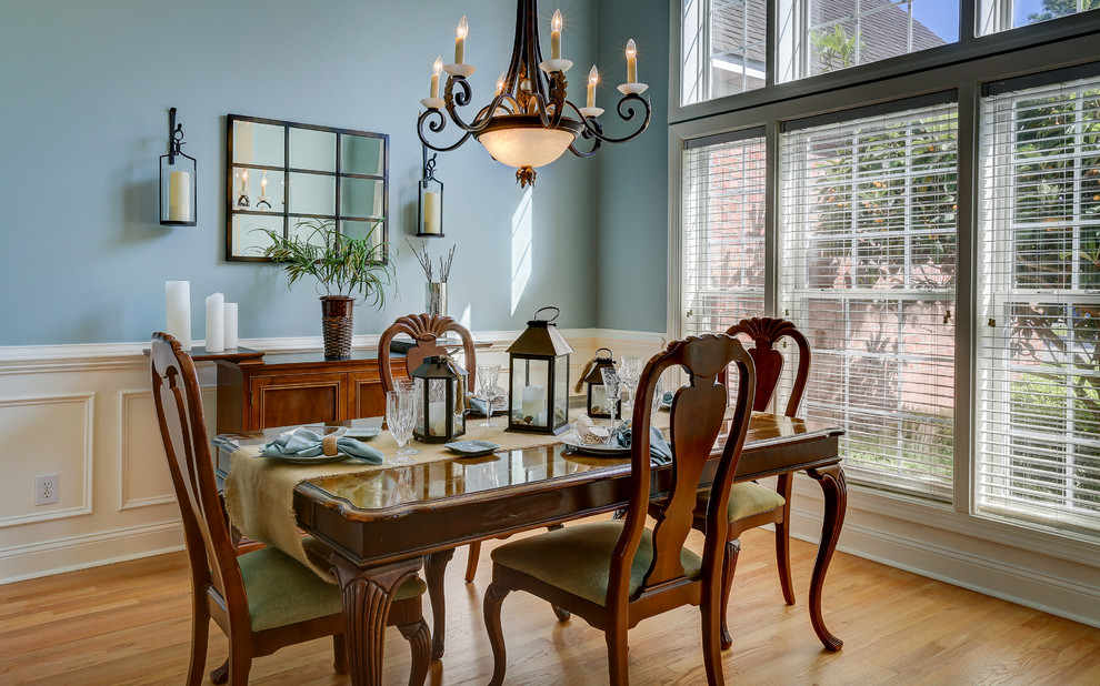 This is an example of a mid-sized transitional separate dining room in Other with blue walls, light hardwood floors and no fireplace.